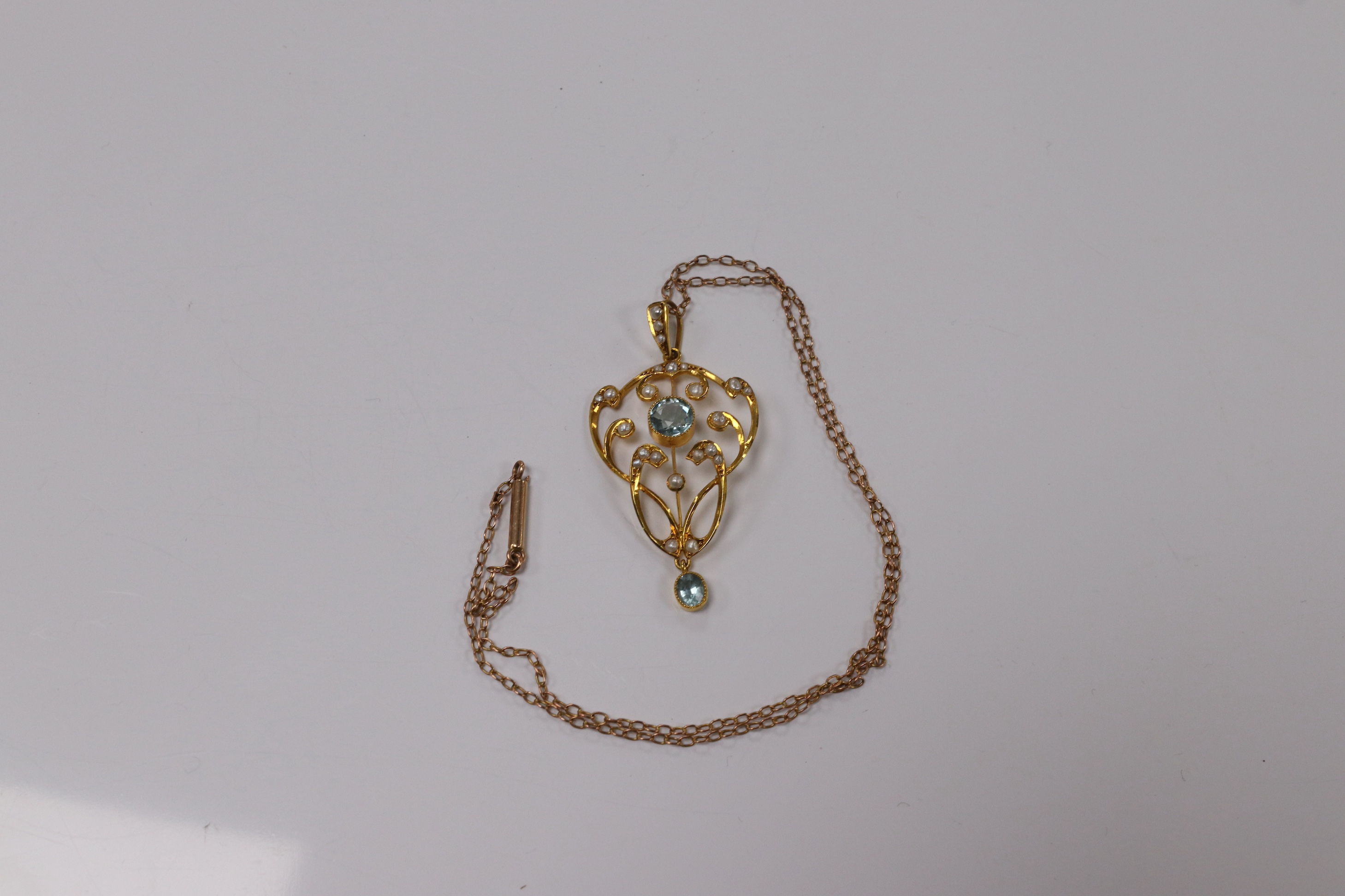 An Edwardian 9ct and gem set drop pendant, 45mm, on a yellow metal fine link chain, 36cm, gross weight 4.2 grams. Condition - good